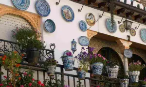 Decorazioni pareti esterne fai da te con piatti decorati e vasi fioriti, un tocco di colore e stile.