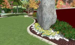 Un grande masso domina un'aiuola con fiori gialli e cespugli rossi. Un'idea per un giardino grande con un tocco naturale.
