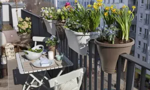 Balcone fiorito con esposizione sud ovest. Tavolino apparecchiato con insalata e fiori primaverili, ideale per godersi il sole.