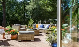 Un'accogliente area relax in rattan con divani e poltrone, perfetta per godersi le **idee spazio esterno casa** in un giardino lussureggiante.