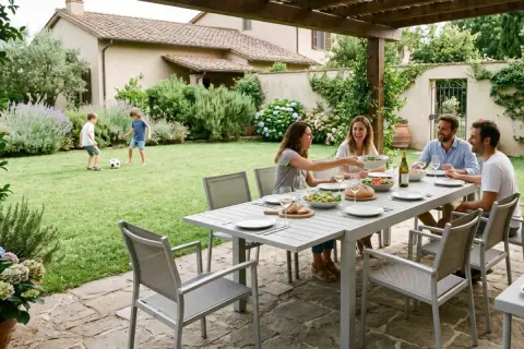 Famiglia che cena all'aperto, bambini giocano a pallone. Belle idee cortile esterno per momenti conviviali.