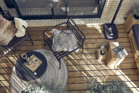 Arredare una veranda piccola: sedie comode, tavolino, divanetto pallet e piante creano un angolo accogliente.