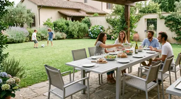 Famiglia che cena all'aperto, bambini giocano a pallone. Belle idee cortile esterno per momenti conviviali.