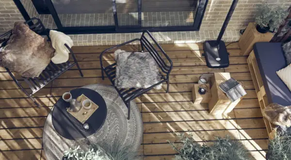 Arredare una veranda piccola: sedie comode, tavolino, divanetto pallet e piante creano un angolo accogliente.