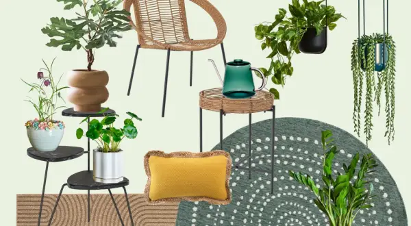 Un accogliente giardino sul terrazzo piccolo con sedia in rattan, piante rigogliose, un annaffiatoio verde e un tappeto decorativo.
