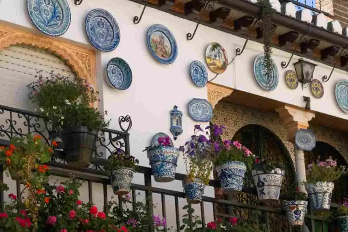 Piatti decorativi e vasi fioriti creano splendide decorazioni pareti esterne fai da te, un tripudio di colori e arte.