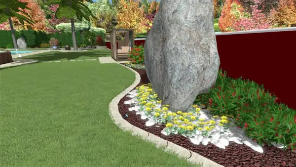 Un grande masso domina un'aiuola con fiori gialli e cespugli rossi. Un'idea per un giardino grande con un tocco naturale.